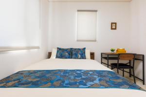 浦添市にあるNaha area #15 min drive to airport #New villaのベッドとナイトスタンド付きのテーブルがある寝室