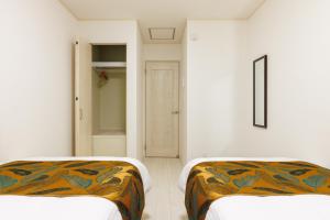 浦添市にあるNaha area #15 min drive to airport #New villaの白い壁の部屋にベッドが2つある