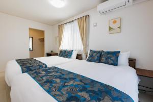 浦添市にあるNaha area #15 min drive to airport #New villaの大きなベッドと窓のあるホテルの部屋