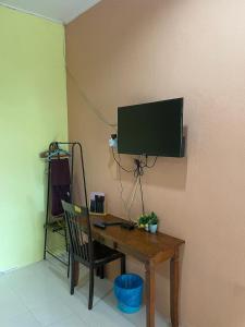 a desk with a computer monitor on a wall at Teratak Atok Ajib in Pantai Cenang