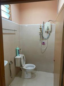 a bathroom with a white toilet and a shower at Teratak Atok Ajib in Pantai Cenang