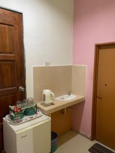 a small kitchen with a sink and a refrigerator at Teratak Atok Ajib in Pantai Cenang