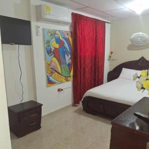 哥伦比亚港Donde Mire的卧室里有一张床，墙上挂着一幅画