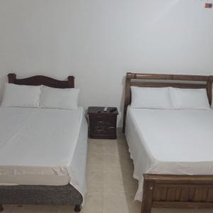 two beds sitting next to each other in a bedroom at Donde Mire in Puerto Colombia