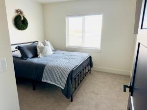 un dormitorio con una cama y una ventana en New 3BR Home w Garage Near BYU-Idaho, en Rexburg