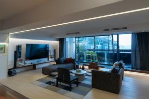 成都市にあるChengdu Kuanzhai Yuntu Serviced Apartmentのソファと大きな窓のあるリビングルーム