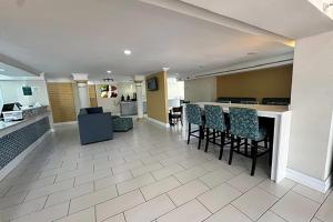 a lobby with a bar and chairs and a kitchen at Baymont by Wyndham Nacogdoches Near University in Nacogdoches