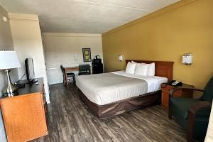 a hotel room with a bed and a desk at Baymont by Wyndham Nacogdoches Near University in Nacogdoches