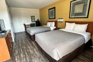 a hotel room with two beds and a flat screen tv at Baymont by Wyndham Nacogdoches Near University in Nacogdoches +22 photos