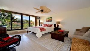 a bedroom with a bed and a living room with a couch at Kaleialoha 401 · KA 401 Spacious Studio w Mountain View Pool AC in Kahana +47 photos