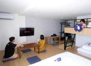 a man and woman playing a video game in a room at Kokotel Rayong Beachfront in Ban Pak Khlong Phe +42 photos