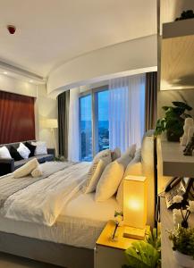 een slaapkamer met een groot bed met een groot raam bij 40 sqm Studio at Aeon Towers in Davao City +24 foto's
