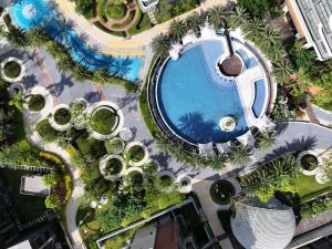 een uitzicht over een zwembad met bomen en planten bij Weili Royal Apartment in Maluan