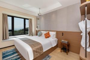 een slaapkamer met een bed en een groot raam bij Weili Royal Apartment in Maluan +23 foto's