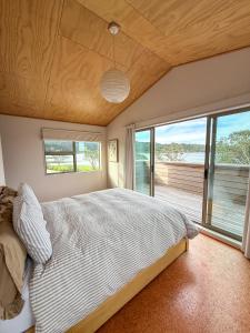 a bedroom with a large bed and a large window at Tranquil Waterfront Getaway - Point Wells in Omaha