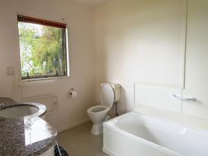 a bathroom with a tub and a toilet and a window at Tranquil Waterfront Getaway - Point Wells in Omaha +13 photos