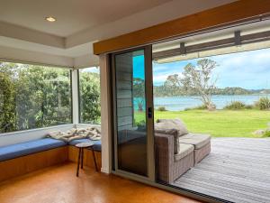 a screened in porch with a couch and a window at Tranquil Waterfront Getaway - Point Wells in Omaha