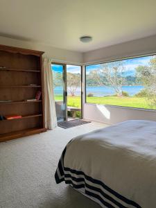a bedroom with a large bed and a large window at Tranquil Waterfront Getaway - Point Wells in Omaha