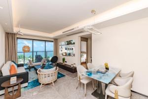 een woonkamer met een glazen tafel en stoelen bij Weili Royal Apartment in Maluan