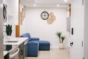 a kitchen with a blue chair and a clock on the wall at Cozy & Stylish 1BR Suite in Regina