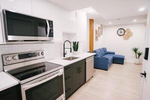 a kitchen with a sink and a microwave above a stove at Cozy & Stylish 1BR Suite in Regina