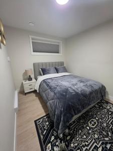a bedroom with a bed with blue pillows and a rug at Cozy & Stylish 1BR Suite in Regina +19 photos