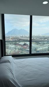 a bedroom with a view of a city from a window at Ideal departamento en Catehua, Monterrey in Monterrey +7 photos
