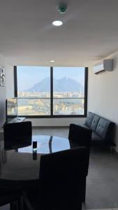 a living room with a couch and a table and a large window at Ideal departamento en Catehua, Monterrey in Monterrey