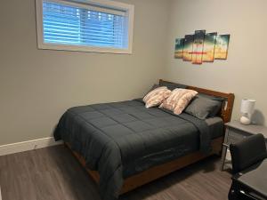 a bed in a room with a window and a bed sidx sidx sidx at Cozy Family Friendly Suite Near Whyte, UofA, Kinsmen with Desks or Home-office and Full Kitchen in Edmonton
