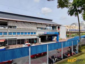 a building with a blue fence in front of a parking lot at SS2 Landed in Petaling Jaya for 8 Pax in Gua Sai