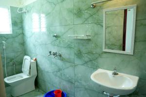 ein Badezimmer mit Waschbecken, Toilette und Spiegel in der Unterkunft Entire 2bhk Premium Home - Kumbha Nivas Homestay in Kumbakonam + 10 Fotos