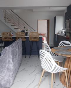 Zimmer mit Stühlen und Tischen sowie einer Küche in der Unterkunft Maison neuve, agréable avec vue mer et montagne in Saint-Pierre