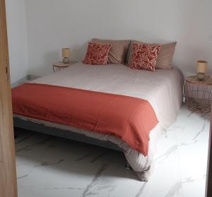 ein Schlafzimmer mit einem großen Bett mit roten Kissen in der Unterkunft Maison neuve, agréable avec vue mer et montagne in Saint-Pierre