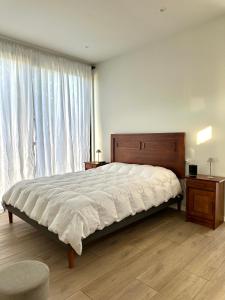a bedroom with a large bed and a large window at Loft Boutique Independiente Cochrane in Cochrane