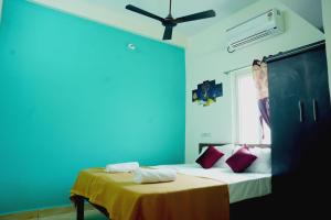 zwei Betten in einem Zimmer mit einer blauen Wand in der Unterkunft Entire 2bhk Premium Home - Kumbha Nivas Homestay in Kumbakonam
