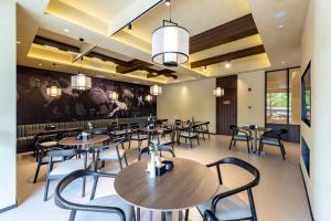 a restaurant with tables and chairs in a room at Jin Yi Hotel Chifeng Victoria Mall Hongshan Government Branch in Liu-tao-fen