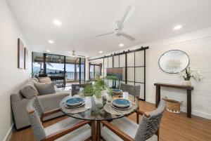 a living room with a table and chairs at Lauloa 403 · LOA 403 Fully Remodeled Direct Oceanfront 2BD in Wailuku