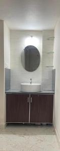 a bathroom with a sink and a mirror at Yashaswi Residency - F001 in Manipala