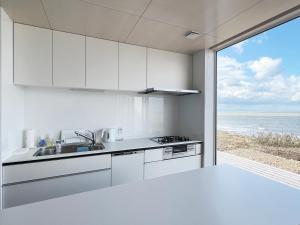a white kitchen with a view of the ocean at Cliff House MORAI 2 in Ishikari