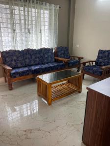 a living room with couches and a coffee table at Yashaswi Residency - F001 in Manipala