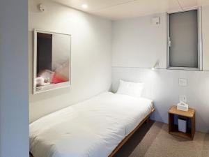 een kleine slaapkamer met een wit bed en een telefoon bij Cliff House MORAI 2  +41 foto's