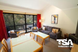 a living room with a couch and a table at Mowamba E6 in Thredbo