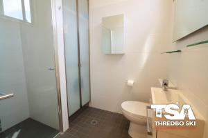 a bathroom with a toilet and a glass shower at Mowamba E6 in Thredbo +11 photos