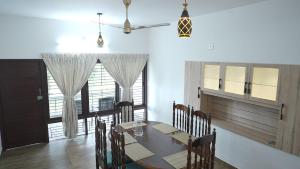 特里凡得琅Spacious & Serene 4BHK Hilltop Villa的一间有桌子、椅子和窗户的餐厅 更多17张照片