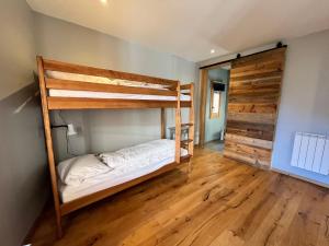 une chambre avec deux lits superposés et un plancher en bois dans l'établissement Chalet rénové à Samoëns, proche centre, skis-bus - FR-1-624-186, à Samoëns