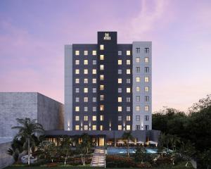un alto edificio nero con una piscina di fronte di Hyatt Place Merida/ Via Montejo a Mérida