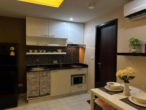 a kitchen with white cabinets and a table with flowers at Room in The Title Rawai Phase 1,2, Condo in Rawai, Room in Rawai, Room in The Title Rawai in Rawai Beach