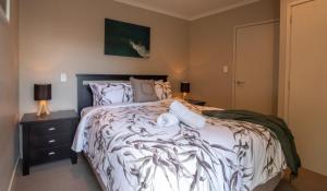 a bedroom with a bed and a night stand with two lamps at Great Location On Gilbert - 3BR 2 level townhouse in New Plymouth +13 photos