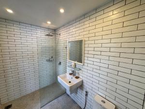 een wit betegelde badkamer met een wastafel en een spiegel bij villa inspiration in Ko Chang +18 foto's