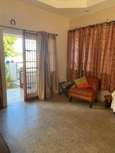 a living room with a chair and a sliding glass door at Secure charming 1-bedroom house in Port-of-Spain